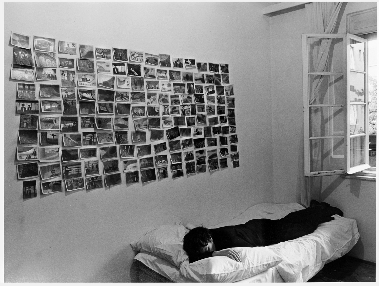 Friedl Kubelka | Franz West lying beneath a wall with his early drawings | 1973 | boa-basedonart